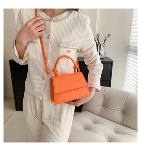 Détail du mini sac orange à motif crocodile avec poignée torsadée et bandoulière
