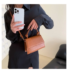 Détail du petit sac carré marron motif crocodile avec poignée nouée et bandoulière