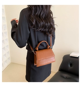 Détail du mini sac marron à motif crocodile avec poignée nouée et bandoulière