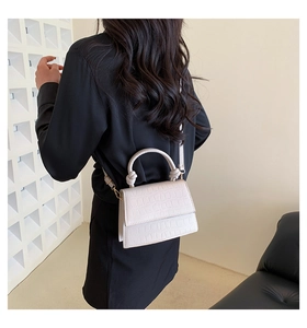 Détail du sac blanc à motif crocodile avec poignée torsadée et fine bandoulière réglable