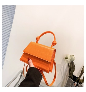 Détail du mini sac à main orange motif crocodile avec poignée nouée et bandoulière