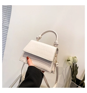 Détail du mini sac à main blanc avec texture crocodile et poignée nouée sophistiquée