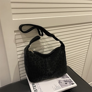 Large capacity leopard print tote bag with adjustable strap and zipper on book background