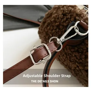 Detail view of adjustable brown leather shoulder strap with silver metal buckle and hooks