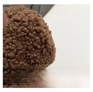 Macro shot of brown faux shearling fabric and premium leather ring detail on a winter bag
