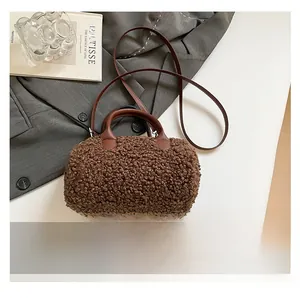 Compact brown fleece cylinder bag shown next to a smartphone for size comparison