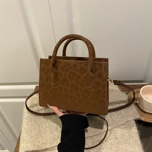 Fashionable leopard print crossbody bucket bag with gold hardware and dual handles