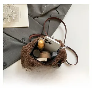 Detail showing the inner capacity of the brown faux shearling pillow bag with daily items