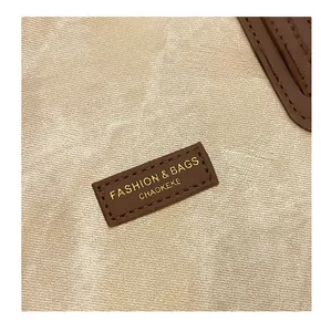 Gros plan sur la toile beige avec empiècement en cuir marron et coutures de haute qualité