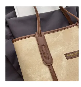Gros plan détaillé des coutures en cuir sur une grande pochette cabas vintage beige