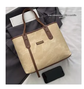 Vue détaillée montrant le grand sac cabas à côté d'un smartphone pour comparer la taille réelle