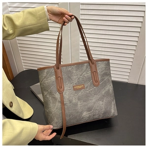 Détail du grand sac cabas gris vintage avec bordure en cuir marron et logo de mode