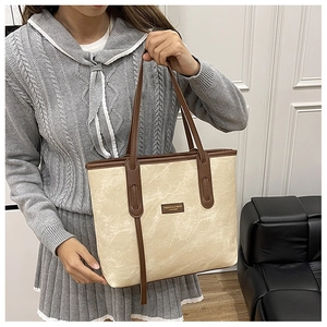 Détail du grand sac cabas avec texture crème et bordures contrastées marron foncé