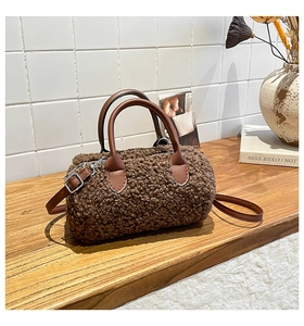 Detailed view of brown plush lamb wool boston bag on wooden table with autumn decor