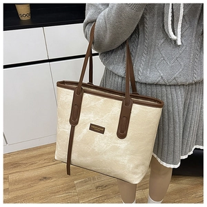 Détail d'un grand sac cabas en toile avec garniture en cuir marron et étiquette de mode