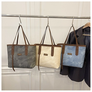 Détail de grands sacs cabas en gris, beige et bleu avec cuir synthétique à texture de pierre