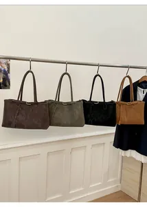Row of four large tote bags in coffee, olive, black, and tan hanging in a minimalist display