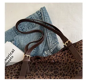 Détail du sac cabas léopard avec bandoulière en cuir, boucle dorée et fermoir magnétique