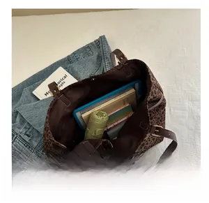Vue détaillée de l'intérieur d'un sac cabas léopard avec livres et accessoires