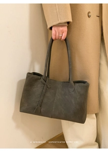 Detailed view of dark grey minimalist tote bag held by a model for professional work
