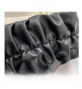 Detailed close-up of premium black pleated leather pouch with soft texture and refined stitching