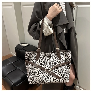 Détail du sac cabas imprimé léopard avec sangles en cuir marron et boucle dorée