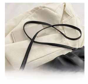 Detail of soft black pleated leather bag with comfortable adjustable thin shoulder strap