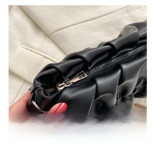 Close-up of the smooth silver metal zipper on the black ruched pleated shoulder bag