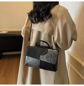 Detail of elegant black and grey snake skin pattern textured flap handbag for women