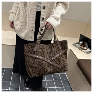 Détail du sac cabas léopard avec lanières en cuir marron dans un décor de bureau