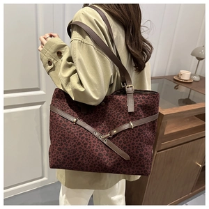 Vue détaillée du sac cabas léopard avec lanières en cuir brun et boucle en métal