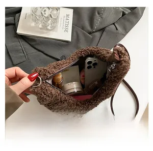 Spacious interior of brown plush shoulder bag showing phone and cosmetics storage