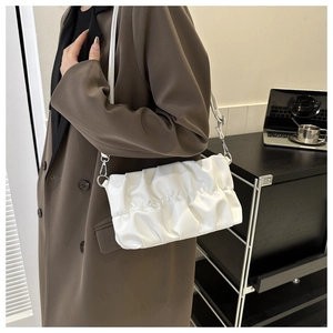 Close-up of a white pleated cloud bag with soft PU leather and silver metal hooks