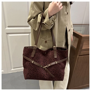 Détail du grand sac cabas léopard bordeaux avec anses en cuir marron et boucle dorée