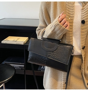 Detail of black faux crocodile texture and lychee grain leather on a stylish handbag