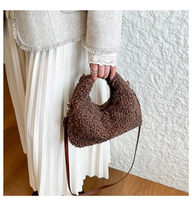Detail of brown teddy fleece crescent bag with slim leather strap and silver hardware