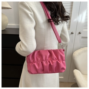 Detailed view of pink pleated cloud bag with shiny texture and silver hardware buckle
