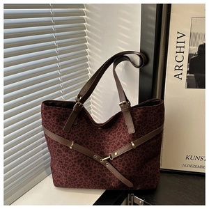 Détail macro du sac cabas léopard rouge vin avec ses bandoulières en cuir réglables