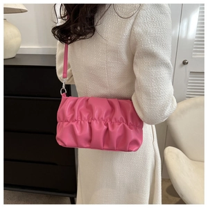 Detail of pink pleated cloud bag with silver buckles on white tweed dress