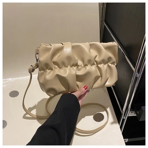 Detail of beige pleated cloud bag with soft faux leather texture and detachable strap