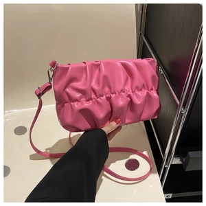 Close-up of bright pink pleated cloud bag with soft PU leather texture and thin strap