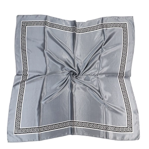 Detail of silver satin square scarf featuring Greek key meander borders in a soft swirl