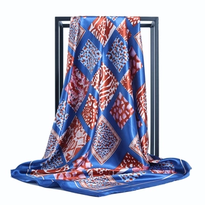 Navy blue satin silk square scarf with animal print patchwork on a minimalist stand