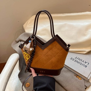 Brown quilted shoulder bag with a bear charm and V-cut design for women