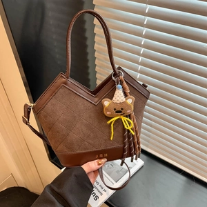 Deep brown quilted bucket bag with leather trim and teddy bear charm for women
