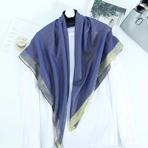 Detail of navy blue shawl with gold thread and wide golden borders on white shirt