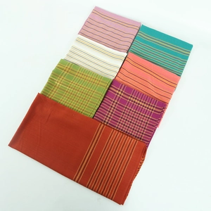 Détail de foulards en coton multicolores superposés avec fils dorés et rayures
