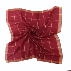 Detailed close-up of red plaid cotton scarf with golden metallic thread grid pattern