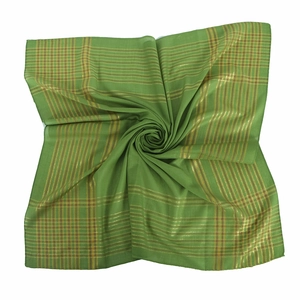 Détail d'un foulard en coton vert avec motif à carreaux en fil d'or et texture