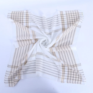 Détail du châle fin en coton avec fils dorés et tissu rayé au drapé fluide et souple